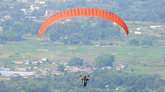 pengunjung bermain paralayang di dataran tinggi sibodiala